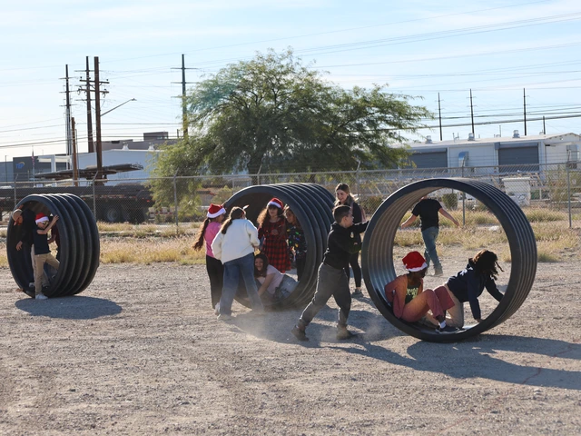 Children play in big tires in a dirt yard