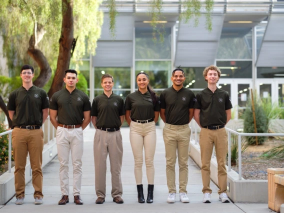 a group of six students poses outdoors