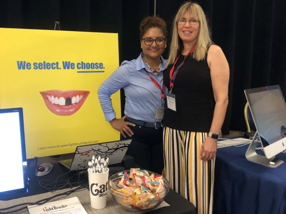 two people stand at a conference booth