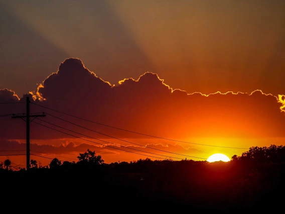 electrical power lines are shown against a sunset