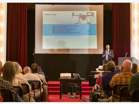 A group of people in an audience watching a presentation on drones