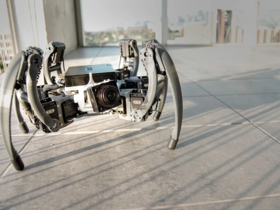 a medium-sized, spider-like robot on a floor