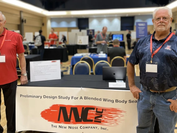 two people stand at a conference booth