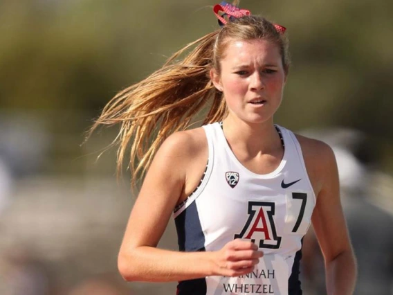 Girl running in University of Arizona team jersey