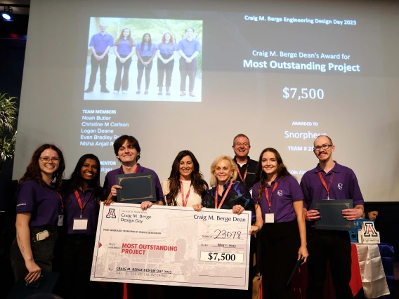 8 people pose with an oversized prize check