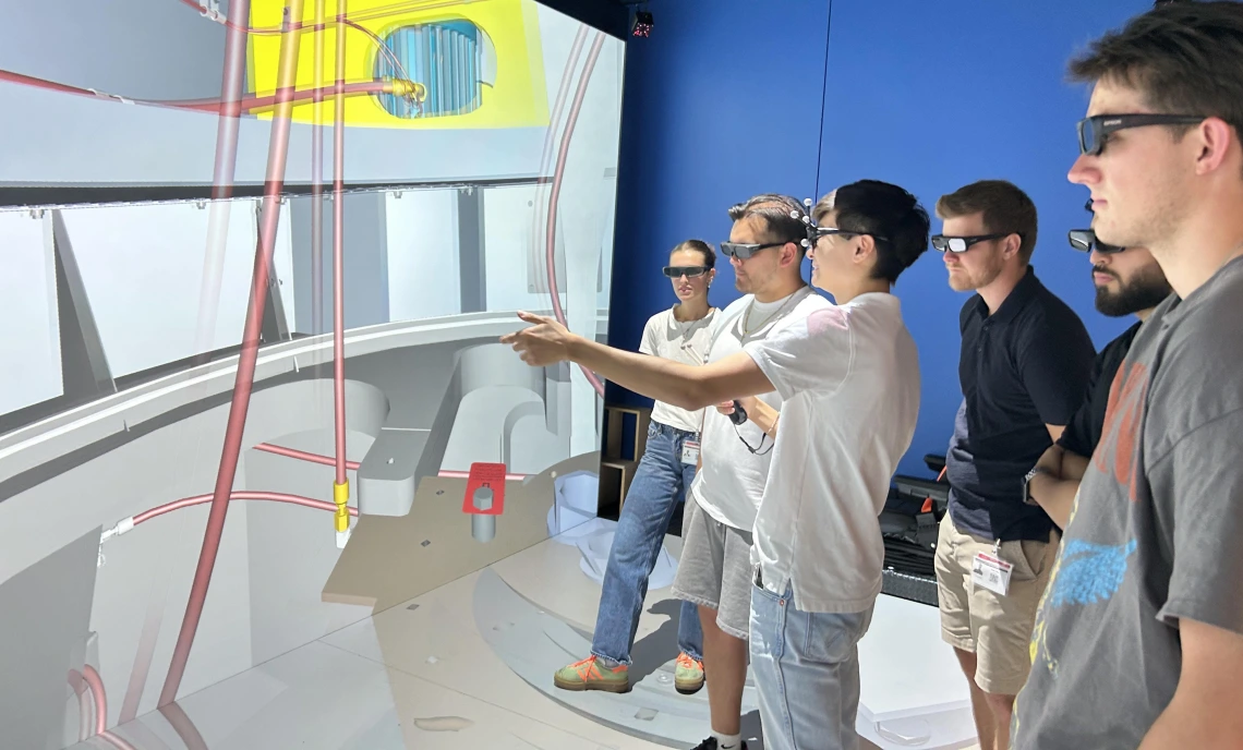 students wearing virtual reality glasses examine an image on a large screen.