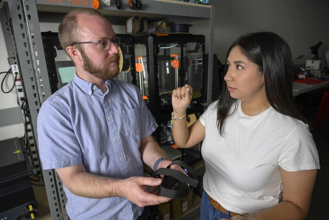 A man and a young woman hold a bike pedal.