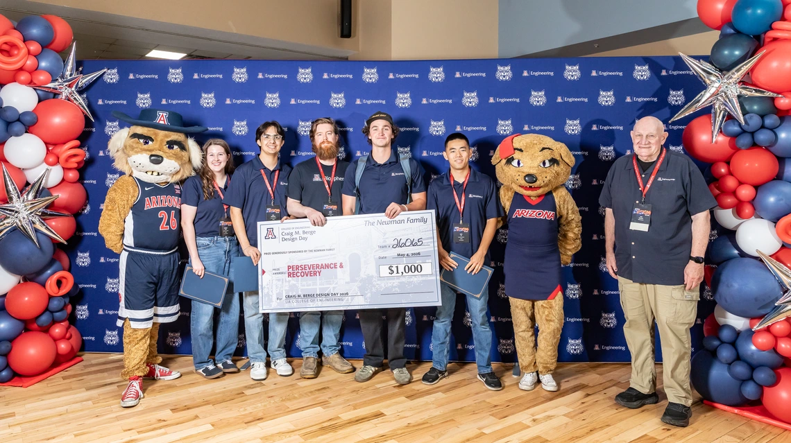 Students pose with a big check