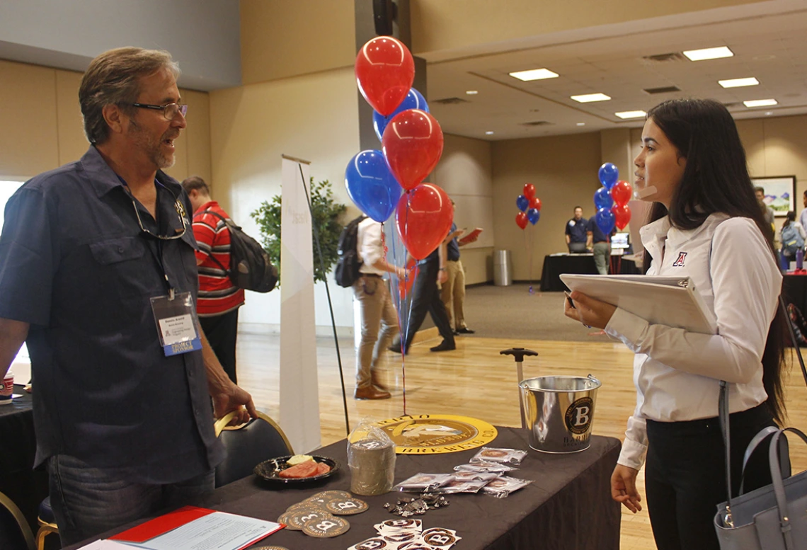 Image of Dennis Arnold talking to student at an open house