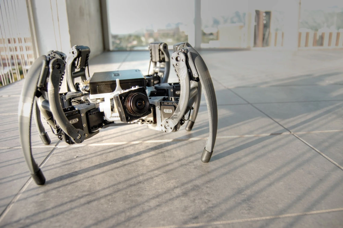 a medium-sized, spider-like robot on a floor