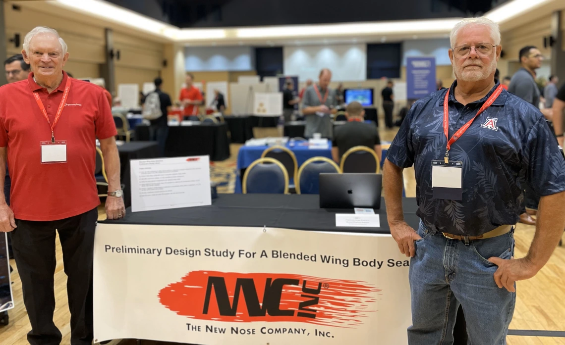 two people stand at a conference booth