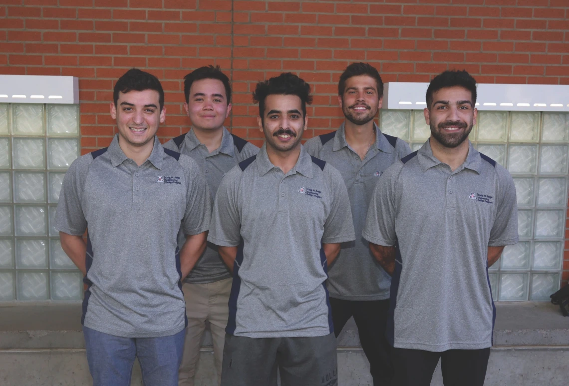 five students posing outside a university building