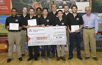 University students with presenter giving them a large award check