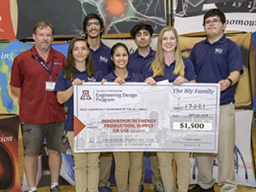 University students with presenter giving them a large award check