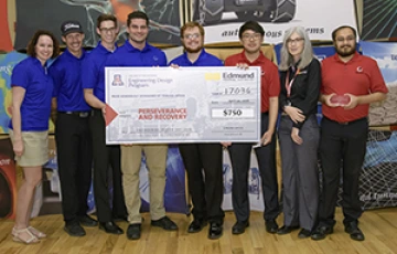 University students with presenter giving them a large award check