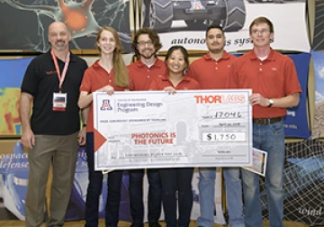 University students with presenter giving them a large award check