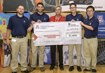 University students with presenter giving them a large award check