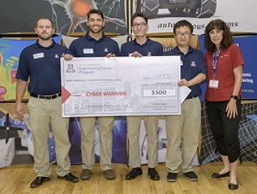 University students with presenter giving them a large award check