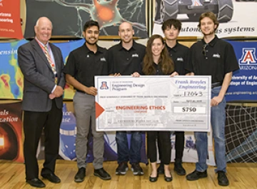 University students with presenter giving them a large award check