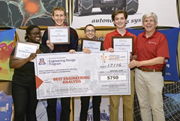 University students with presenter giving them a large award check