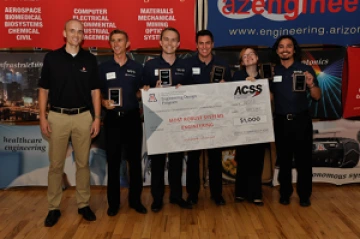 University students with presenter giving them a large award check