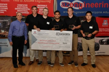 University students with presenter giving them a large award check