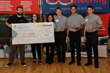 University students with presenter giving them a large award check