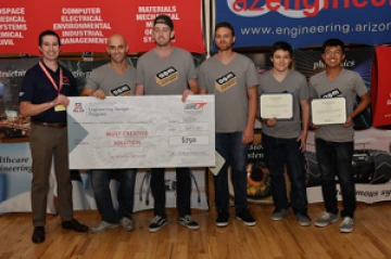 University students with presenter giving them a large award check