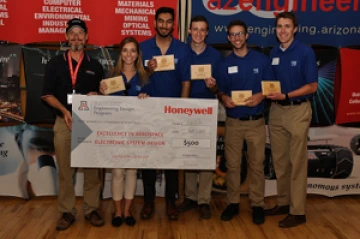 University students with presenter giving them a large award check