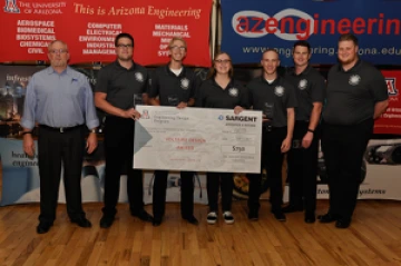 University students with presenter giving them a large award check