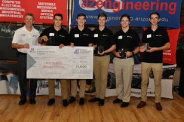 University students with presenter giving them a large award check