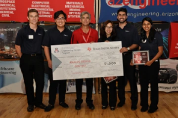 University students with presenter giving them a large award check