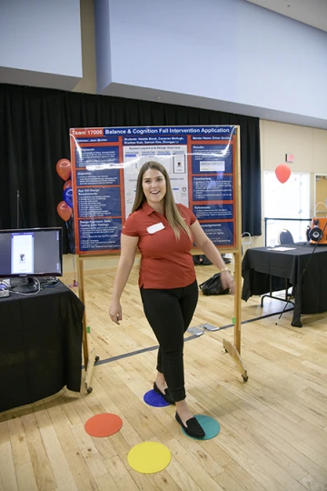 Woman standing with right foot on a green dot and left foot on a blue dot to demonstrate a balance app