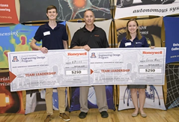 University students with presenter giving them a large award check