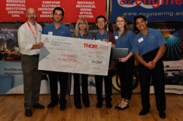 University students with presenter giving them a large award check