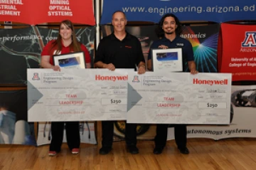 University students with presenter giving them a large award check