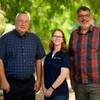 Three employees pose outdoors at the University of Arizona campus