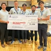 Five men in white shirts hold up a big check.