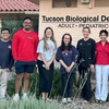 Six students pose for a photo outside a dentist's office with the dentist.