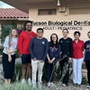 A group of students take a photo with a dentist.