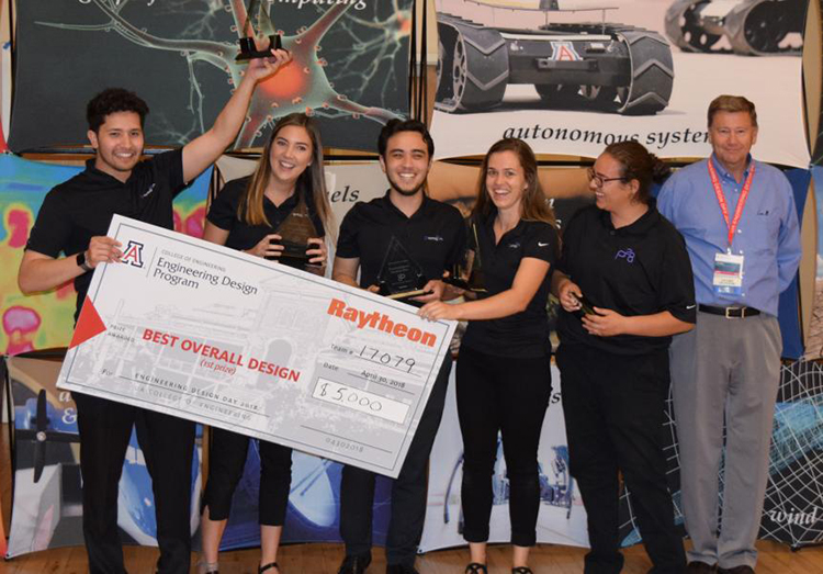 Five university students holding a large check with the presenter from Raytheon