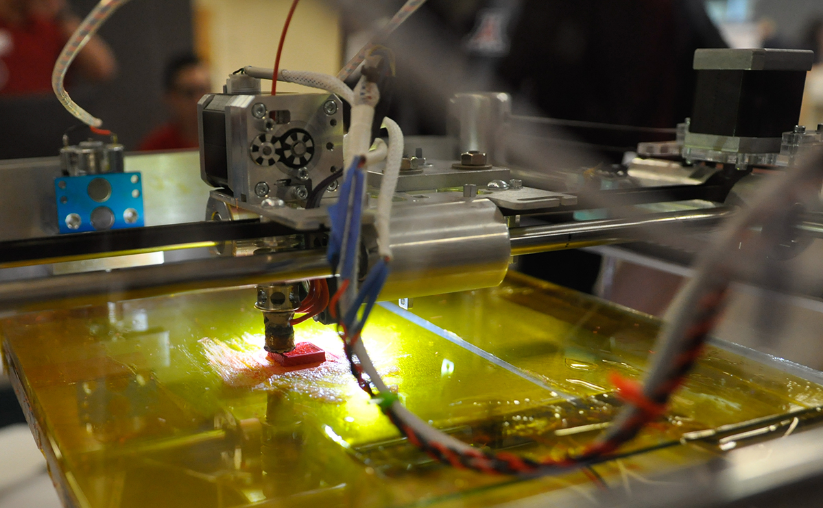 Close up image of a 3D printer making a red object