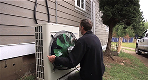 An engineer installs a waste-air reclamation system on an HVAC unit