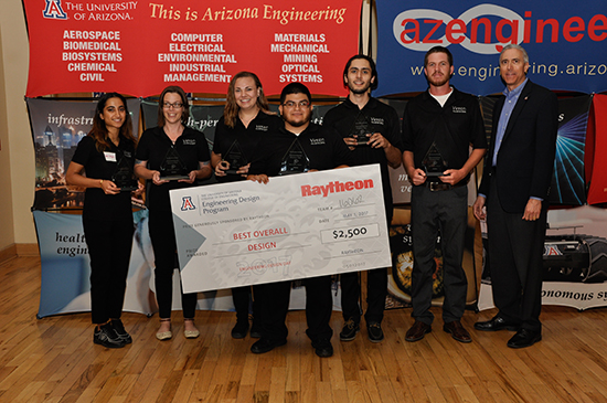 Presenting sponsor and three female and three male students holding triangle-shaped glass awards and a large award check 
