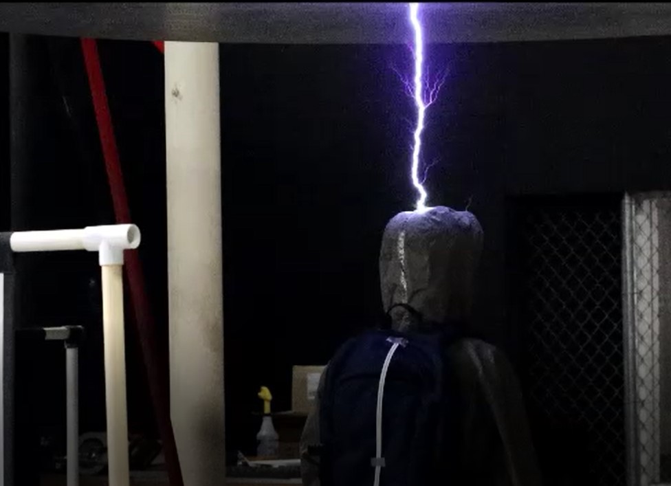 A mannequin in a dark room being struck by lightning