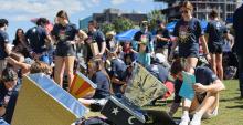 a group of students work outdoors on hand-built solar ovens