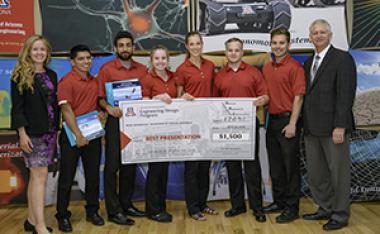 University students with presenter giving them a large award check