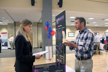 A man talking to a university student at a college event