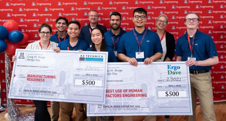 A group of students holds two oversized prize checks