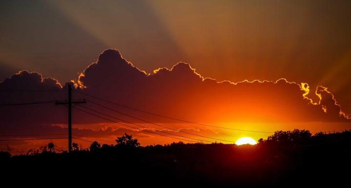 electrical power lines are shown against a sunset